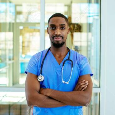 141955472-portrait-of-a-serious-young-male-doctor-or-nurse-wearing-blue-scrubs-uniform-and-stethoscope-with-ar.jpeg